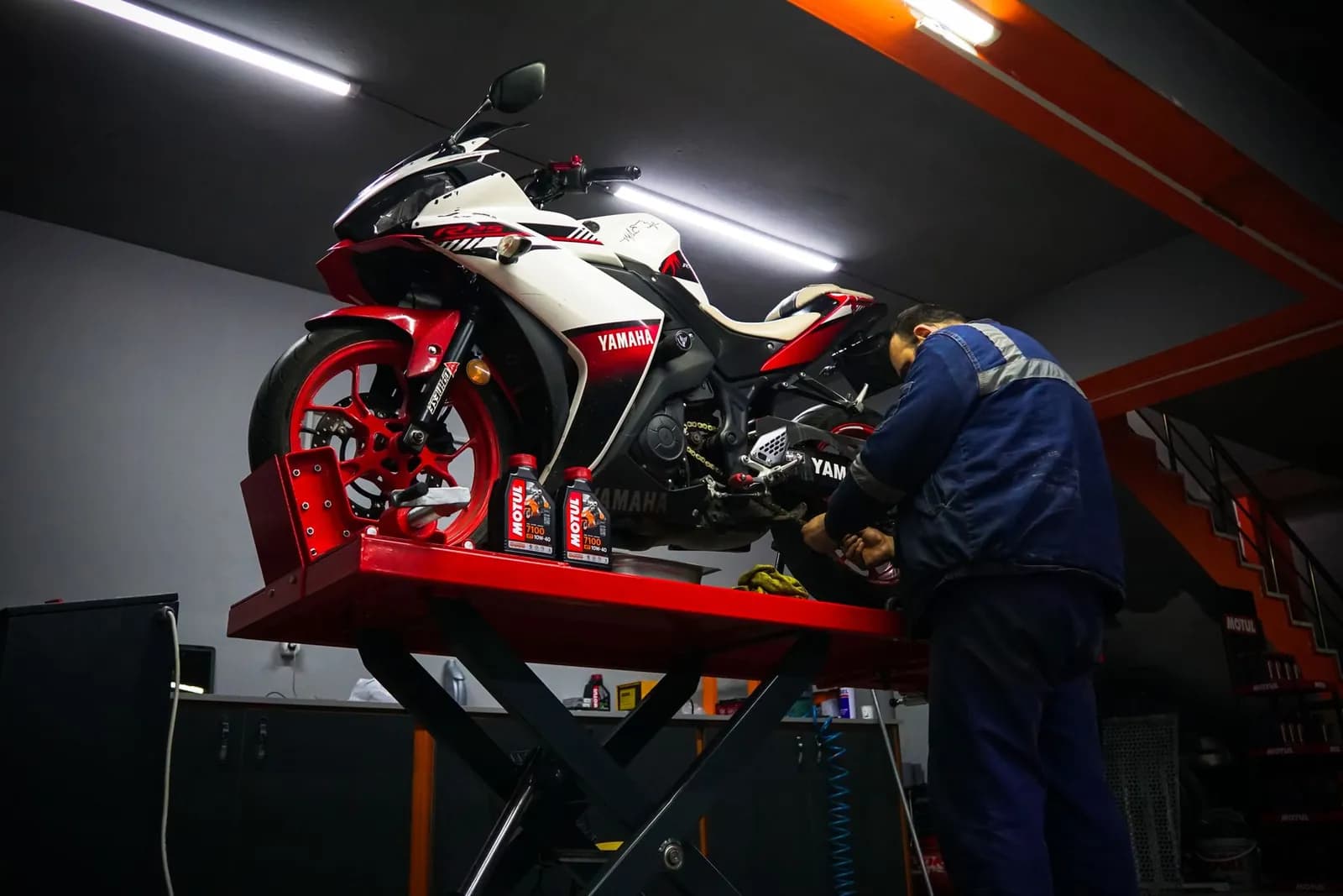 Motorrad auf einer Motorradhebebühne, ein Mann arbeitet daran